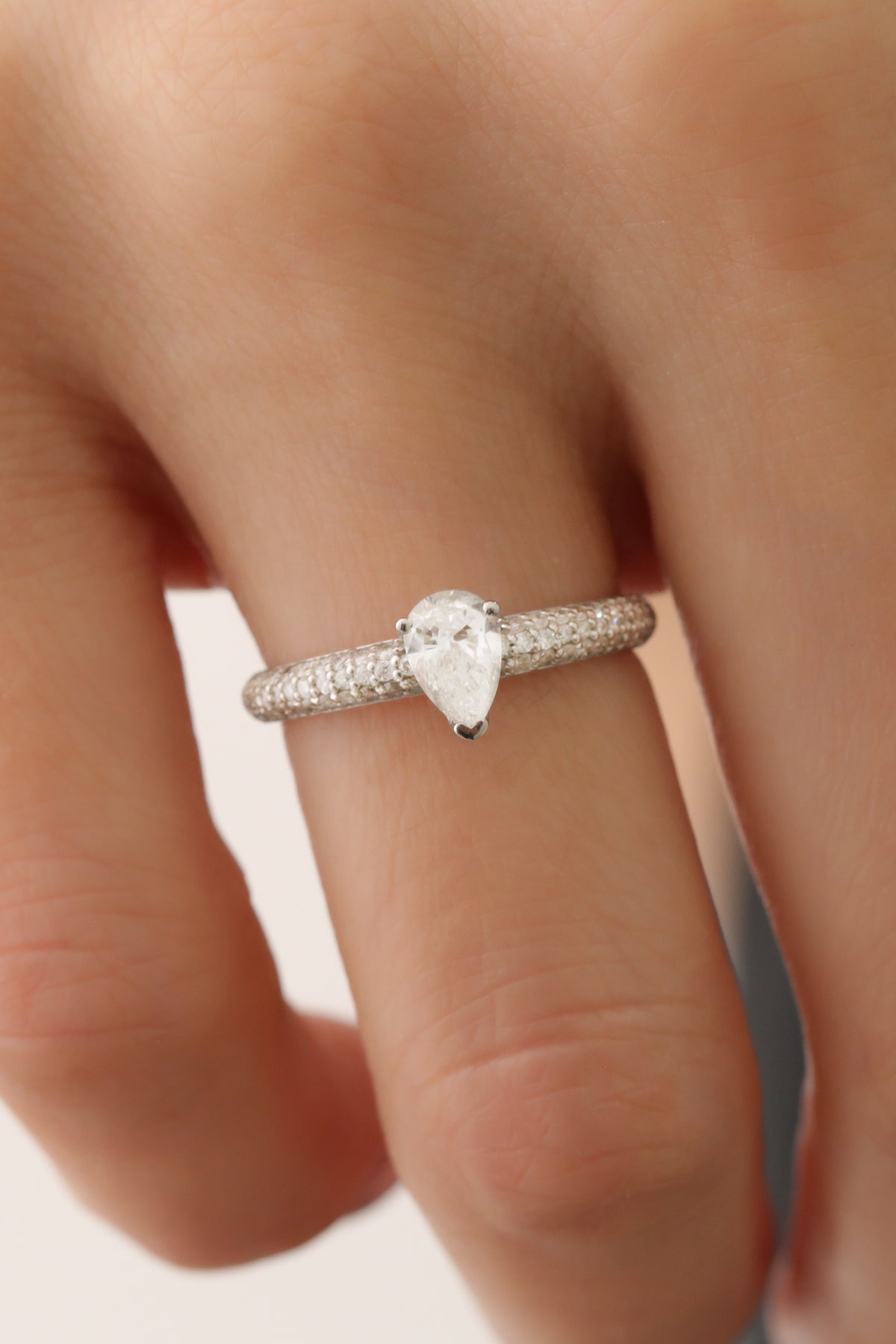 Inel de logodnă cu diamant natural în formă de pară și pavé de diamante, purtat pe mână